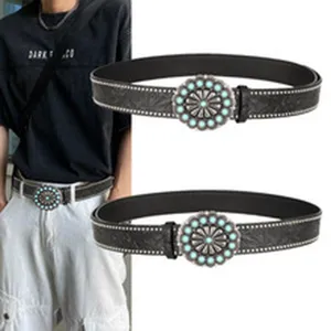 Cinturón de cuero negro estilo punk con hebilla de sol turquesa y tachuelas plata.