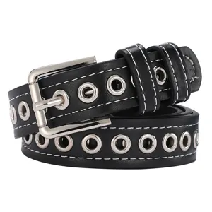Detalle de cinturón punk negro con ojales metálicos plateados y costuras blancas.