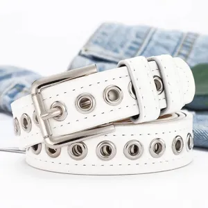 Detalle de cinturón blanco estilo punk con ojales metálicos plateados y hebilla clásica