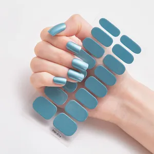 Vista de detalle de las pegatinas para uñas azul metálico con 16 piezas en la mano