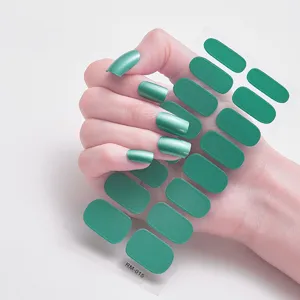 Vista detallada de pegatinas de esmalte de uñas verde metálico aplicadas en la mano