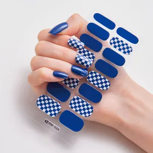 Pegatinas de uñas metálicas a cuadros azules y lisas en uñas y hoja de pegatinas.