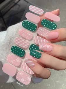 Nahaufnahme von rosa und grünen Weihnachts-Nagelstickern mit Schneeflocken und Glitzer