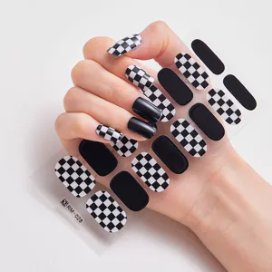 Primer plano de pegatinas de uñas de tablero de ajedrez en blanco y negro aplicadas