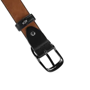 Detail shot of black leather belt featuring gunmetal oval pin buckle and brown suede lining.
