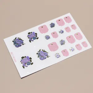 Detail shot of floral toe nail stickers with pink glitter and gold studs, 22 pieces.