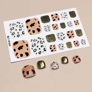 Macro detail of leopard pattern and metallic gold toe nail stickers on a 22-tip sheet