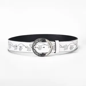 Close-up of a white vintage leather belt with floral embossing and round silver buckle.