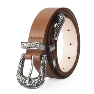 Close-up of brown women's belt with ornate silver western carved buckle and metal tip