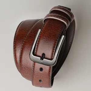 Gros plan d'une ceinture en cuir marron pour homme avec boucle en alliage texturé vintage.