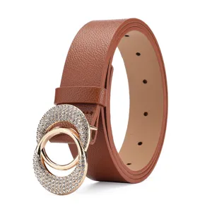 Close-up detail of brown leather belt with luxury rhinestone double circle gold buckle