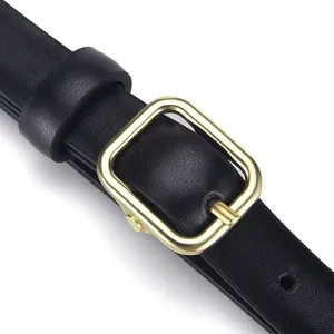 Macro detail of a slim black leather belt featuring a polished gold square pin buckle