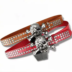 Gros plan sur la boucle de ceinture tête de mort strass et clous pyramidaux style punk.