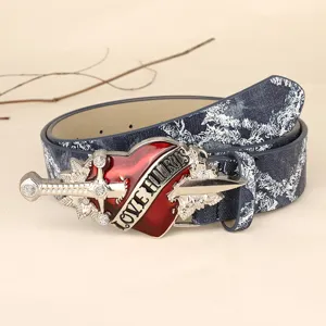 Punk style retro washed denim belt with metal red heart dagger buckle detail view.