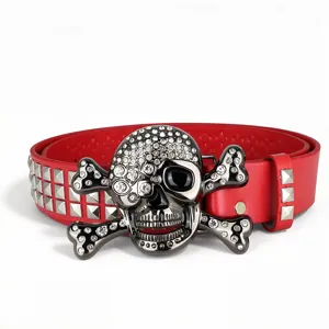 Ceinture en cuir rouge style punk avec boucle tête de mort strass et clous pyramidaux.