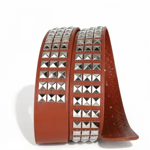 Gros plan détaillé d'une ceinture punk en cuir marron avec trois rangees de clous pyramides.