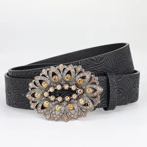 Detail of vintage black leather belt with ornate rhinestone floral buckle