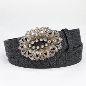 Detailed view of vintage embossed leather belt with ornate rhinestone floral buckle
