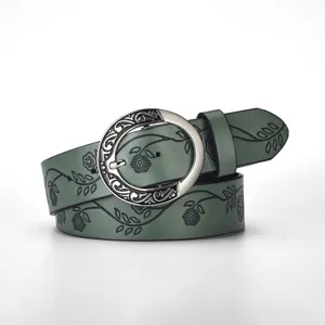 Detailed close-up of a green vintage leather belt featuring a floral pattern and silver buckle