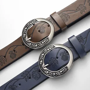 Detailed view of vintage embossed leather belts featuring ornate silver circular buckles