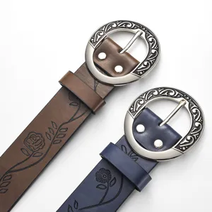 Close-up of vintage wide leather belts with engraved metal buckles and floral patterns