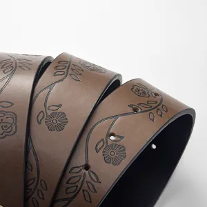 Macro view showing the embossed black floral pattern on a retro brown leather belt