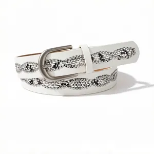 Close-up of a white fashion belt for women featuring decorative wavy rhinestone patterns