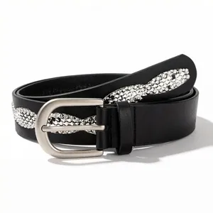 Macro view of a black fashion belt featuring silver rhinestone waves and matte buckle