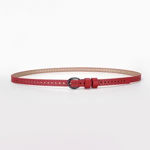 Detail view of a red narrow belt with hollow perforated pattern and dark pin buckle.