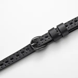 Close-up detail of black perforated women's skinny belt with a sleek silver pin buckle