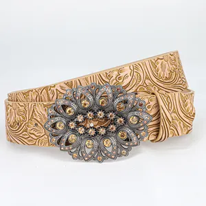 Close-up detail of a retro embossed leather belt with an ornate hollow rhinestone buckle.
