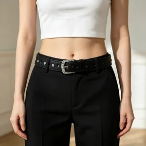 Close-up of a black leather belt with a rhinestone heart-shaped buckle and studs