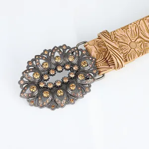 Close-up of vintage hollow-out belt buckle with amber rhinestones and floral pattern