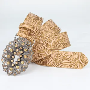 Vintage floral embossed leather belt with ornate rhinestone buckle for fashion jeans.