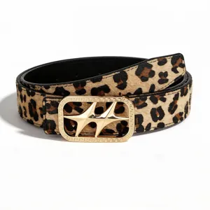 Primer plano de cinturón reversible de leopardo con hebilla dorada de estrella de cuatro puntas