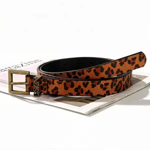 Close-up of leopard print belt with D.SIGN metal buckle and textured animal pattern