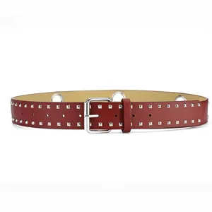 Close-up detail of the red studded punk leather belt with metal grommets and a silver buckle.