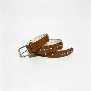 Detail macro view of brown shiny belt with heart cutouts and rhinestone buckle.