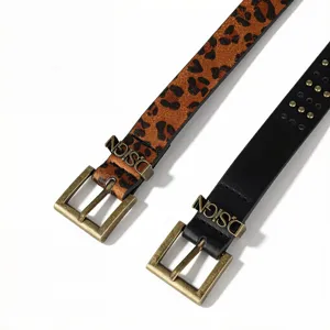 Detail of leopard print and black leather punk belts with engraved D.SIGN metal buckles.