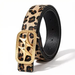 Primer plano de cinturón reversible con hebilla de estrella dorada y estampado de leopardo.