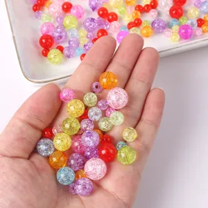 Detail shot of colorful crackle glass beads in hand, perfect for DIY jewelry making and crafts.