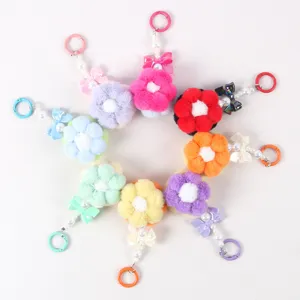Detailed view of colorful plush flower keychains with beads and bows in a circle