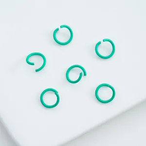 Detailed macro view of teal lacquered alloy open jump rings for DIY jewelry craft projects