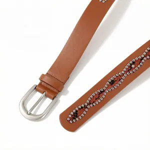 Close-up view of a brown leather belt featuring a silver buckle and rhinestone wave pattern