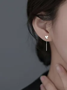 Vue détaillée de boucles d'oreilles minimalistes en argent avec trèfle à l'oreille