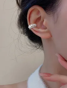 Detailed close-up showing a silver double-layered twist ear cuff with shiny zircon stones
