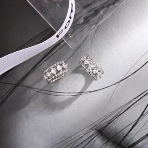 Macro detail of double-layer twisted silver ear clips with sparkling round zircons