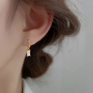 Primo piano di eleganti ganci per orecchi placcati in oro con zircone rettangolare