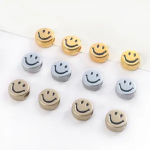 Close-up of metallic smiley face flat beads in gold and silver for DIY jewelry making