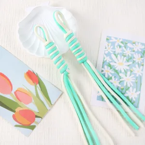 Close-up of handmade braided Roman knot lanyards in fresh mint green and white cord